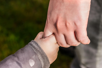 Child hand holding an adult hand