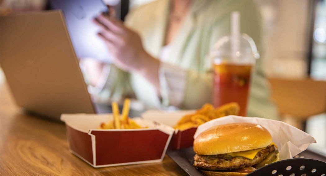 young professional with burger and French fries for lunch