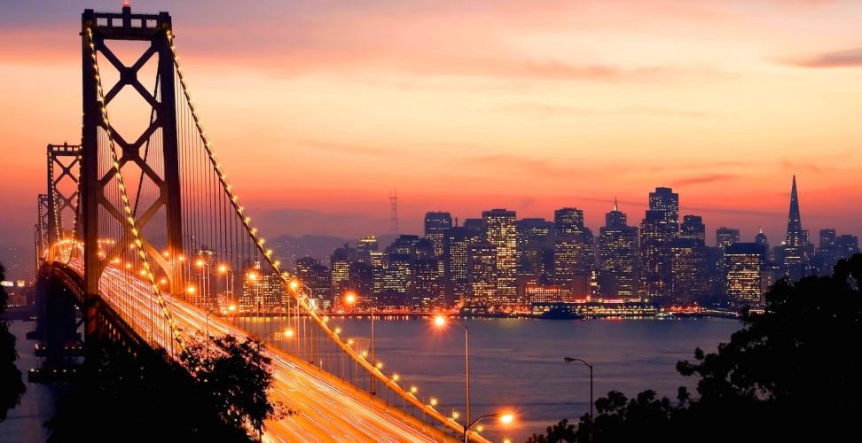Bay Bridge and city skyline at sunset