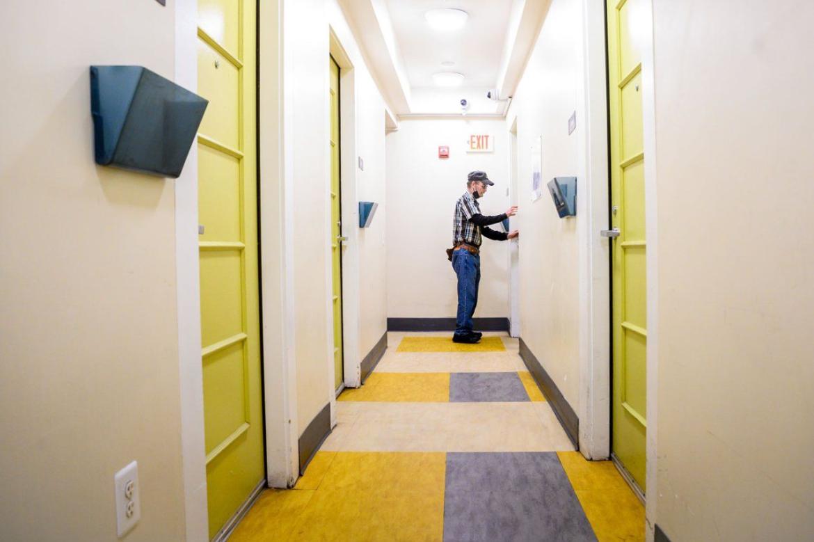 Man standing outside door in a hallway