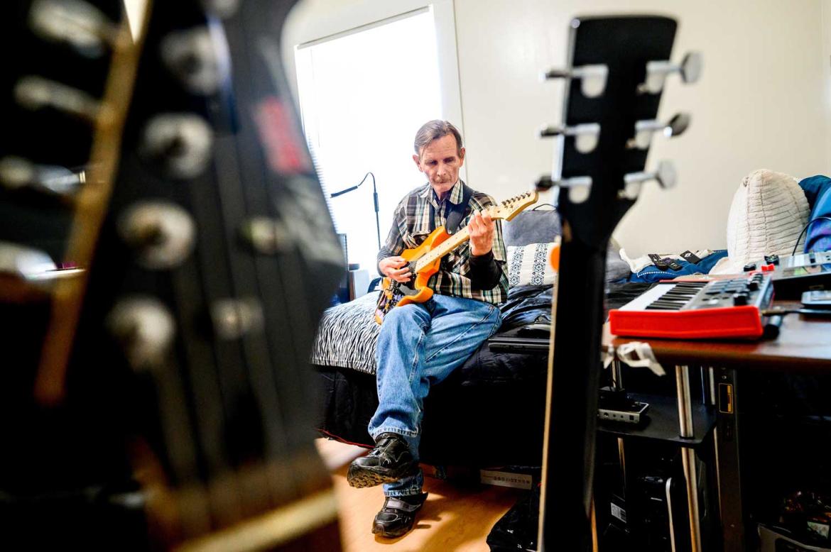 Seated man playing a guitar