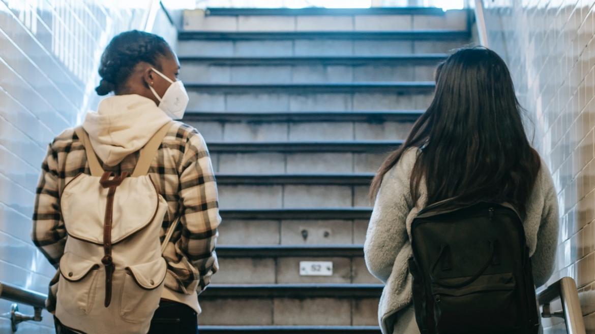 Two people ascending a staircase in a subway station