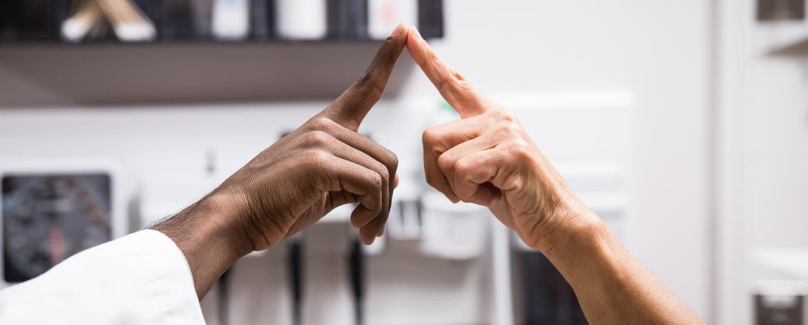 Two people touching the tips of their index fingers together