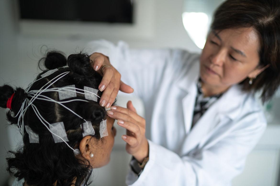 Person having a sensors placed on their head by a technician