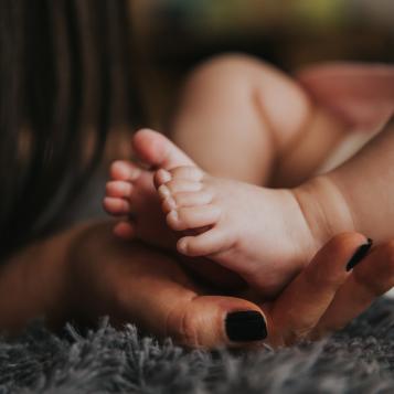 Baby feet cradled by a woman's hands
